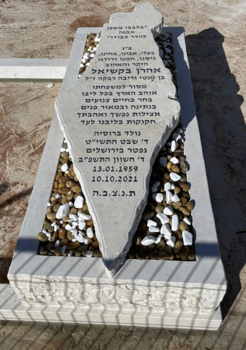 מצבה מעוצבת שוכבת, מאבן בגוון אפור מעוצבת כמפת ישראל
