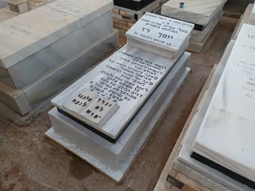 מצבה בודדת עם כרית מרובעת בראש המצבה וספר פתוח למרגלותיה